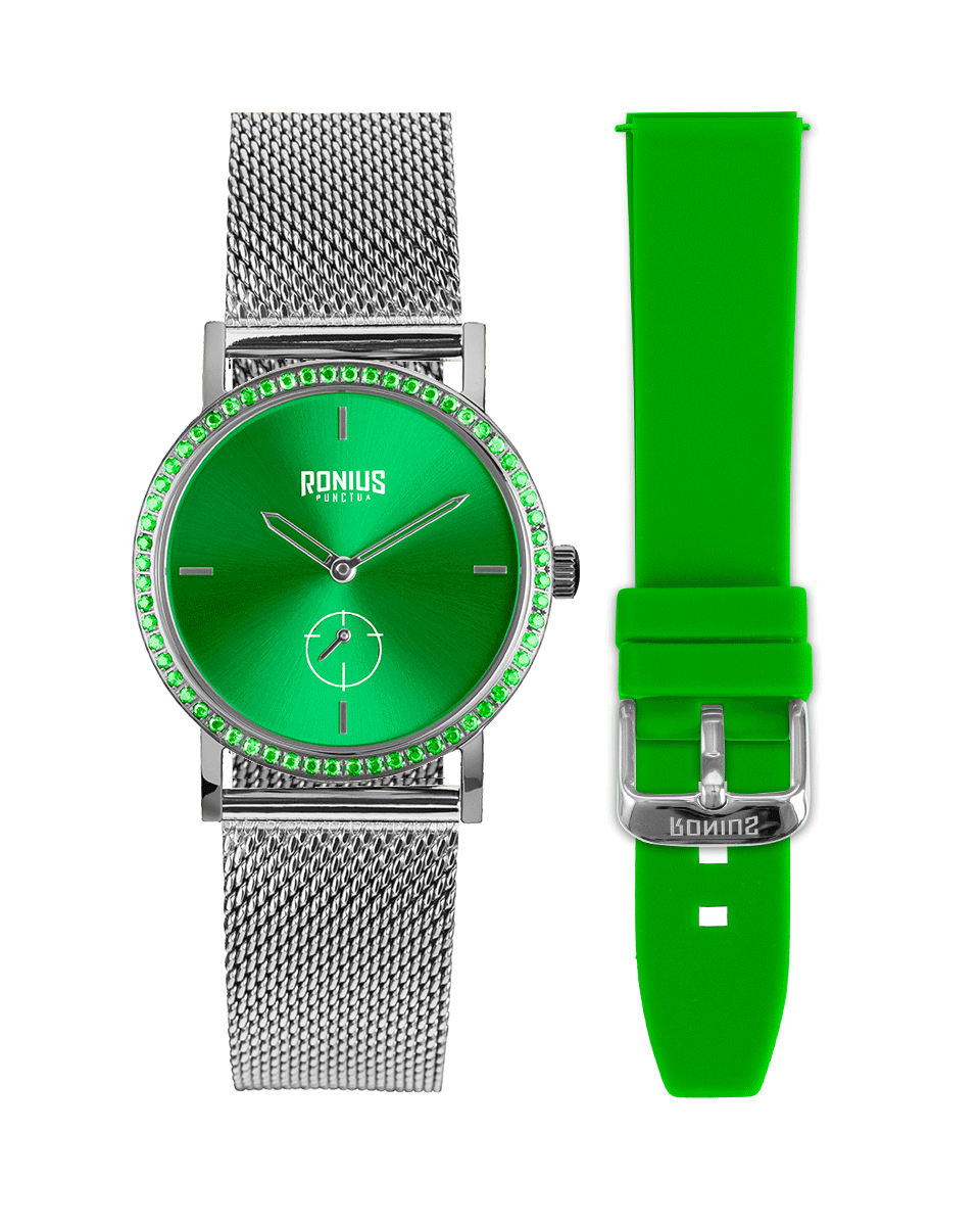 A burst of light and personality.

The emerald-green dial, framed by matching sparkling stones, delivers a vibrant elegance that stands out effortlessly. The silver stainless-steel case and mesh strap give it a fresh, modern attitude, while the included green silicone strap lets you switch the look in seconds—from refined to sporty, always with unmistakable style.